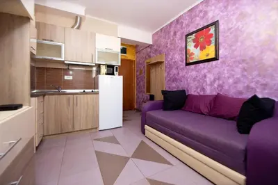 a living room with a purple couch in a kitchen at Central Budva M Lux Apartments in Budva