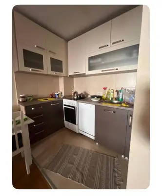 a small kitchen with white cabinets and white appliances at Sshome in Podgorica