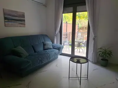 a living room with a blue couch and a table at Green Harmony in Kotor