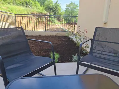 two chairs sitting on a porch with a garden at Green Harmony in Kotor