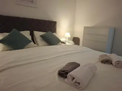 a white bed with towels on top of it at Green Harmony in Kotor