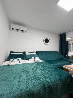 a bedroom with a green bed and a couch at Budva apartman Vasić in Budva