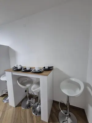 a bar with two stools and a table with cups at Budva apartman Vasić in Budva