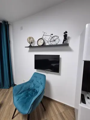 a living room with a blue chair and a tv at Budva apartman Vasić in Budva