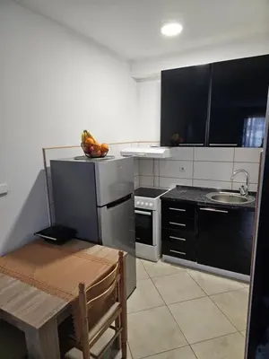 a kitchen with black appliances and a table with a chair at Studio Apartment Blue Dream in Kotor