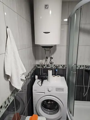 a small bathroom with a washing machine and a cabinet at Studio Apartment Blue Dream in Kotor