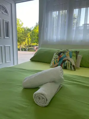 a green bed with two towels on top of it at Casa Calda Apartments in Cetinje