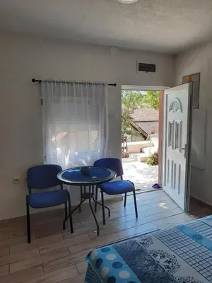 a table and chairs in a living room with a patio at Casa Calda Apartments in Cetinje
