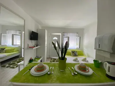 a living room with a table with plates and utensils at Casa Calda Apartments in Cetinje