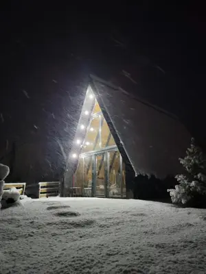 a barn in the snow at night at Cottage MATEJ in Podgorica