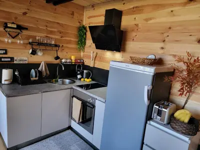 a kitchen with a refrigerator and a sink at Cottage MATEJ in Podgorica