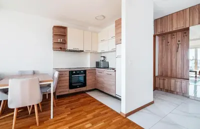 a kitchen with wooden cabinets and a table and chairs at Sea-view PD38 by In Property in Budva