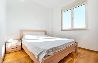 a white bedroom with a bed and a window at Sea-view PD38 by In Property in Budva