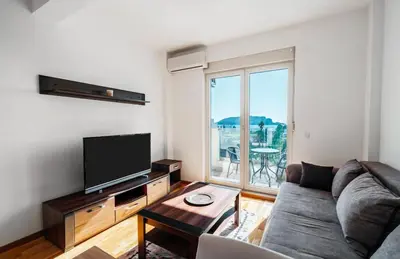 a living room with a couch and a flat screen tv at Sea-view PD38 by In Property in Budva