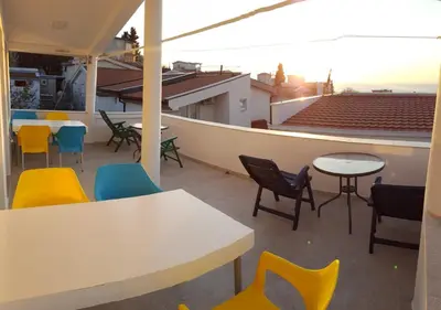 a patio with tables and chairs on a roof at Dzenan apartmani in Dobra Voda