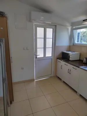a small kitchen with a door and a window at Dzenan apartmani in Dobra Voda