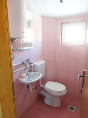 a bathroom with a toilet and a sink at Dzenan apartmani in Dobra Voda