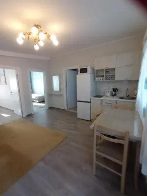 a kitchen with a table and a white refrigerator at Dubrava 112 in Dobra Voda