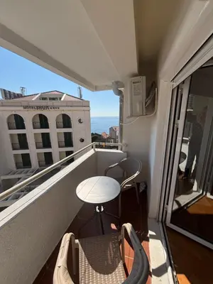 a balcony with a table and chairs and the ocean at Apartman Horizont in Petrovac na Moru