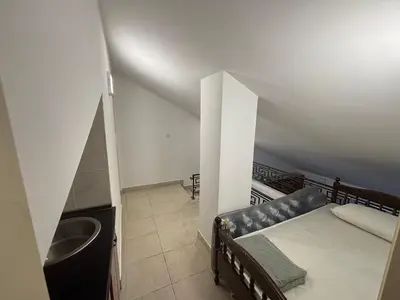 a small room with a bed and a sink at Apartman Horizont in Petrovac na Moru