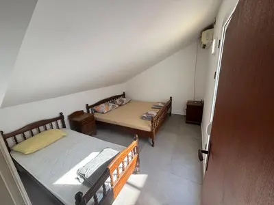a small bedroom with two beds and a table at Apartman Horizont in Petrovac na Moru
