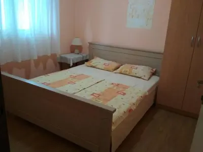 a bedroom with a bed and a night stand with a lamp at Comfort Apartments in Bar
