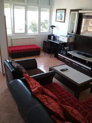 a living room with a couch and a tv at Comfort Apartments in Bar
