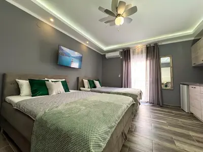 a bedroom with two beds and a ceiling fan at Villa Sun Budva in Budva