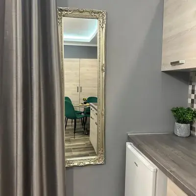 a mirror on a wall with a table in a room at Villa Sun Budva in Budva