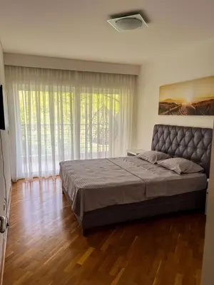 a bedroom with a large bed and a large window at Sky apartment - Becici in Becici