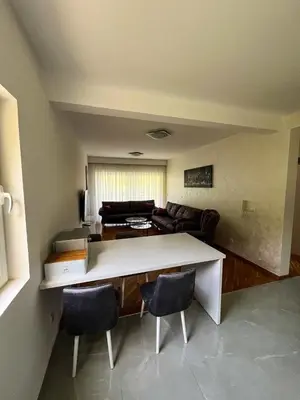 a living room with a table and chairs and a couch at Sky apartment - Becici in Becici