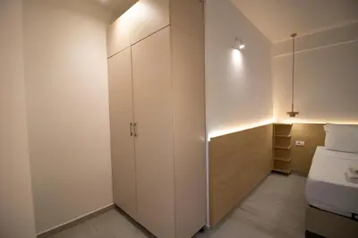 a bedroom with a white cabinet and a bed at Alpesa Apartments in Budva