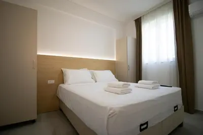 a bedroom with a white bed with towels on it at Alpesa Apartments in Budva