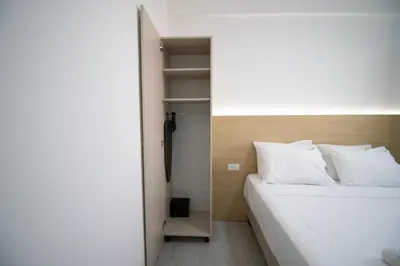 a bedroom with a white bed and a closet at Alpesa Apartments in Budva