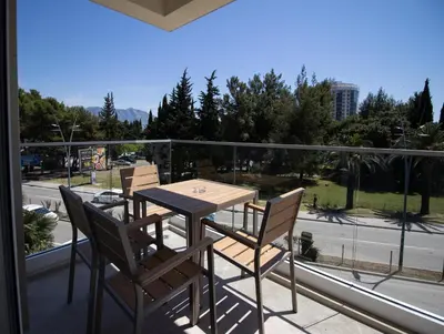 a table and chairs on a balcony with a view of a street at Alpesa Apartments in Budva