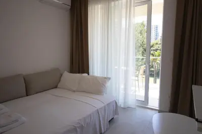 a living room with a couch and a large window at Alpesa Apartments in Budva