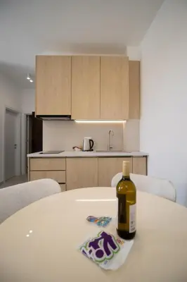 a bottle of wine sitting on a table in a kitchen at Alpesa Apartments in Budva