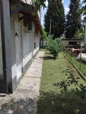 an empty sidewalk next to a house with a yard at Nikolaj in Podgorica