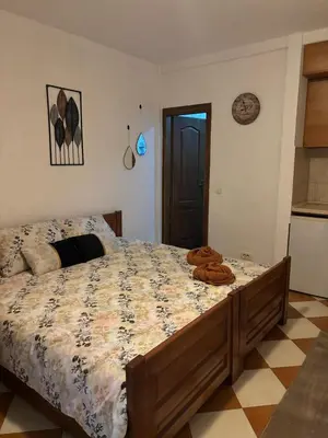 a bedroom with a bed with a comforter on it at Nikolaj in Podgorica