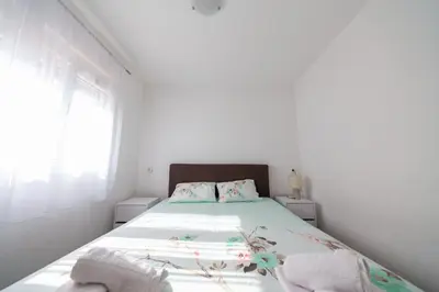 a white bedroom with a bed with a window at Villa Bojana in Neodi