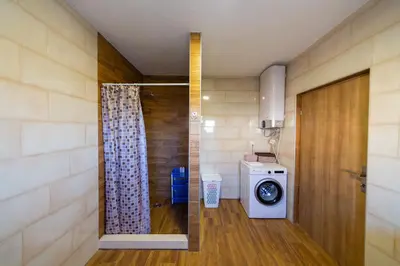 a bathroom with a washer and dryer in a room at Villa Bojana in Neodi