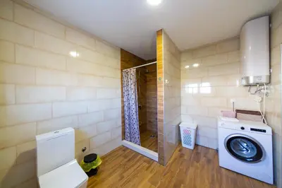 a bathroom with a washing machine and a shower at Villa Bojana in Neodi