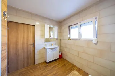 a bathroom with a sink and a wooden door at Villa Bojana in Neodi