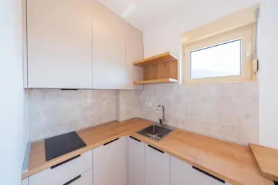 a kitchen with white cabinets and a window at Luča Apartments in Budva
