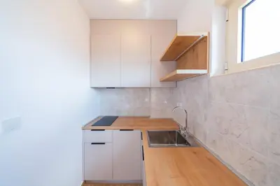 a kitchen with white cabinets and a sink at Luča Apartments in Budva