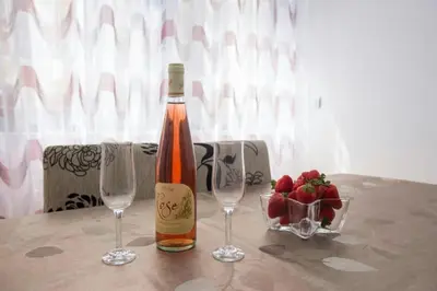 a bottle of wine with two glasses and a bowl of strawberries at Sea Point apartment Korda in Budva