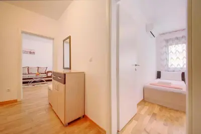 a small bedroom with a bed and a mirror at Sea Point apartment Korda in Budva