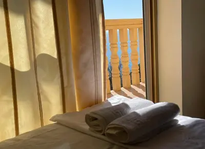 a towel on a bed in front of a window at SOHO Apartments in Ulcinj