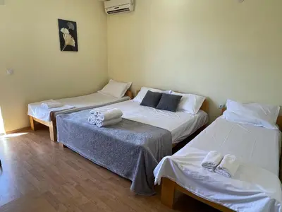 three beds in a room with white sheets at SOHO Apartments in Ulcinj