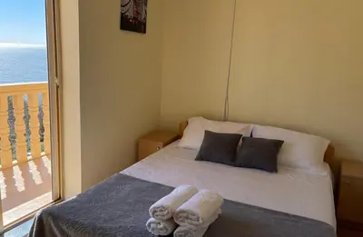 a bedroom with a bed and a balcony with the ocean at SOHO Apartments in Ulcinj